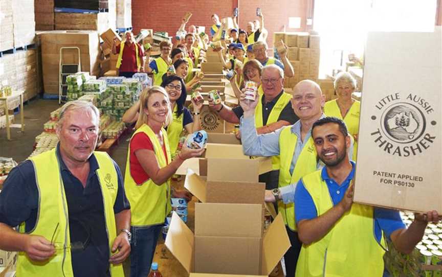 Volunteers packing hampers at Foodbank WA's warehouse