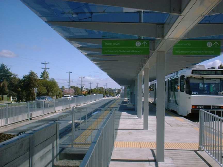 A tram station with a tram waiting for passengers