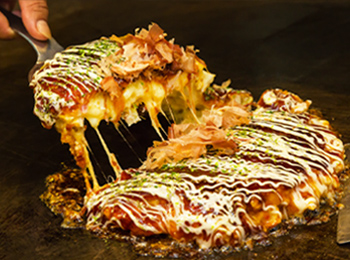 dish that is covered in cheese and sauce being sliced up
