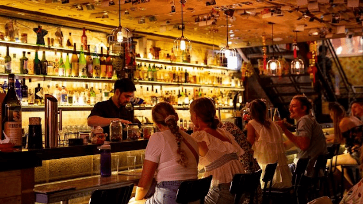 bar with people ordering from a bartender